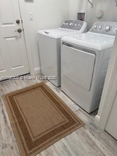 26047 SW Viterbo Way, Port St Lucie, FL 34986 - clothes washing area featuring light wood finished floors, laundry area, and washing machine and dryer