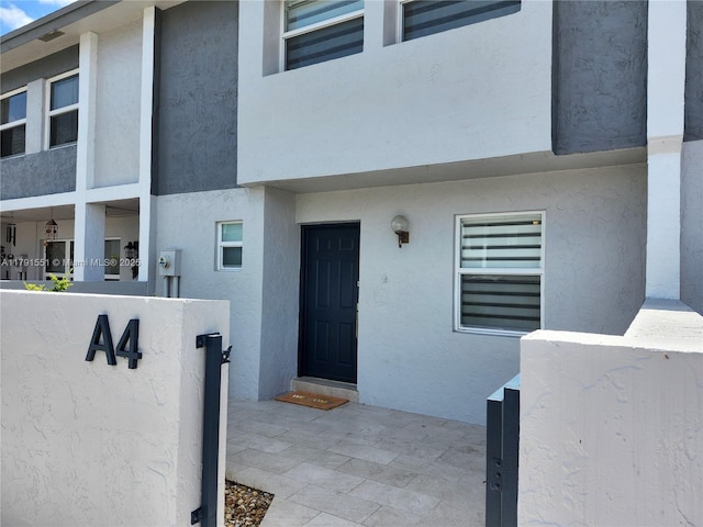 view of exterior entry featuring stucco siding