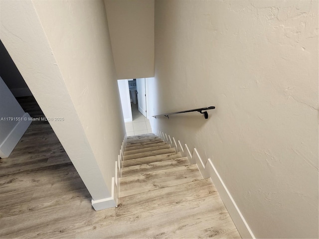 staircase with wood finished floors and baseboards