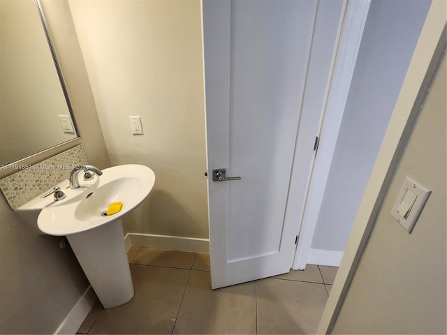 bathroom with a sink, tile patterned floors, and baseboards