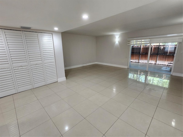 empty room featuring baseboards, visible vents, light tile patterned flooring, and recessed lighting