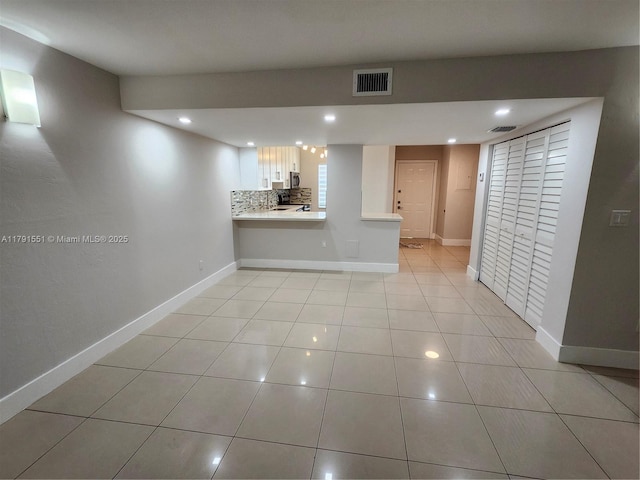 unfurnished living room featuring light tile patterned floors, visible vents, recessed lighting, and baseboards