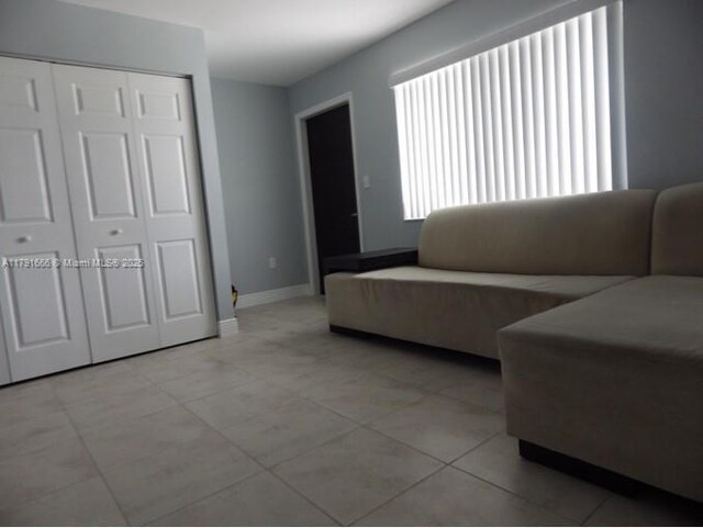 1990 NW 4th Ct Unit 8, Miami, FL 33136 - living area featuring light tile patterned flooring and baseboards