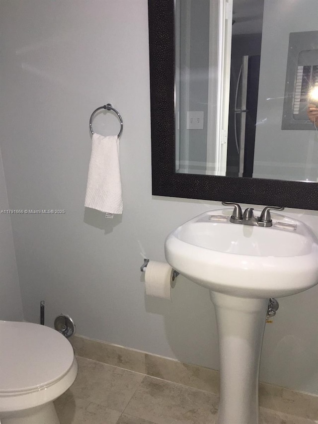 1990 NW 4th Ct Unit 8, Miami, FL 33136 - half bathroom with toilet, tile patterned flooring, and baseboards