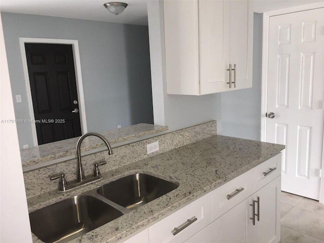 1990 NW 4th Ct Unit 8, Miami, FL 33136 - kitchen featuring light tile patterned flooring, white cabinetry, light stone countertops, and a sink