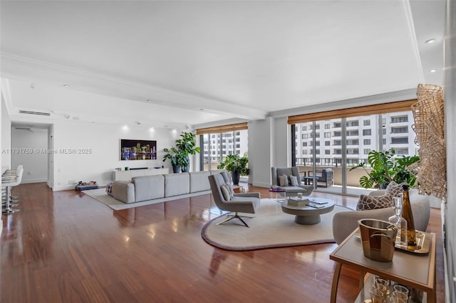 living area with visible vents, wood finished floors, and baseboards