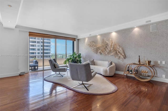 living area with wood finished floors, visible vents, and baseboards