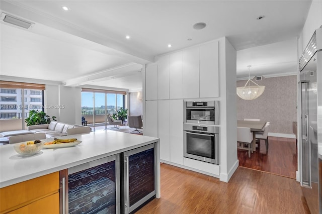 kitchen featuring visible vents, modern cabinets, light wood finished floors, and wine cooler