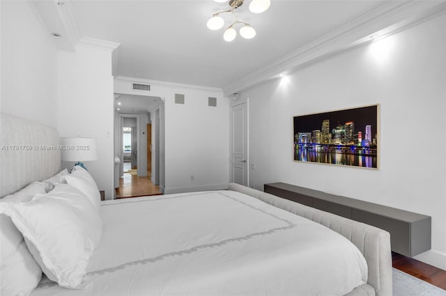 bedroom with a chandelier, visible vents, wood finished floors, and crown molding