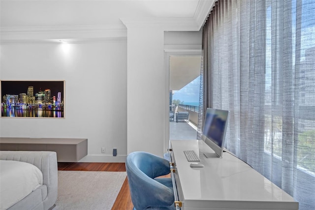 bedroom featuring ornamental molding and wood finished floors