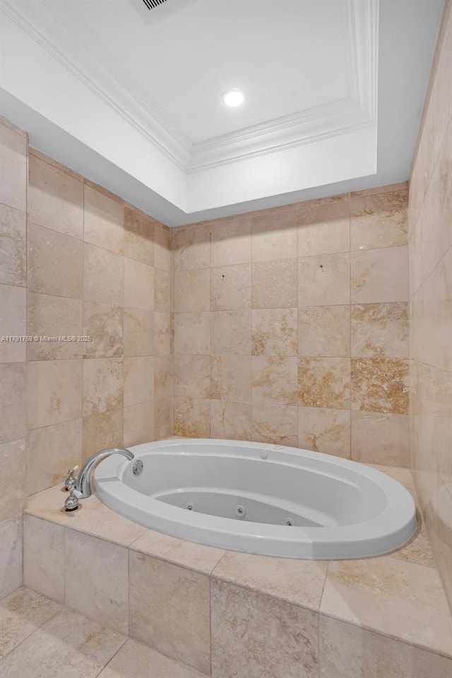 bathroom with ornamental molding and a jetted tub