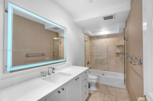bathroom featuring vanity, toilet, visible vents, enclosed tub / shower combo, and tile patterned flooring