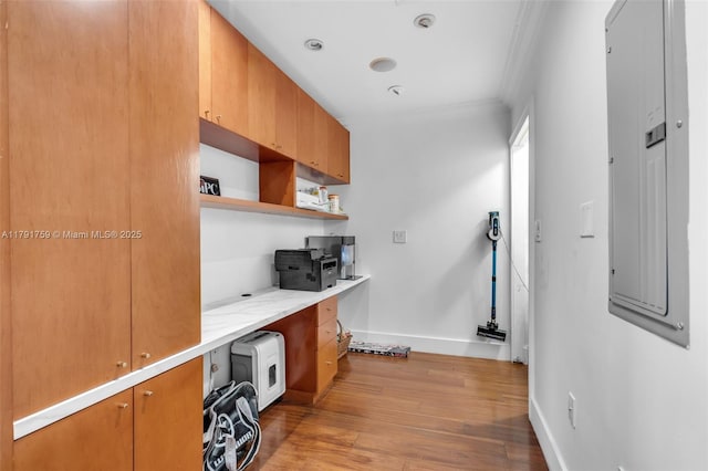 kitchen with open shelves, crown molding, built in study area, baseboards, and wood finished floors