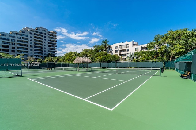 view of tennis court featuring fence and community basketball court