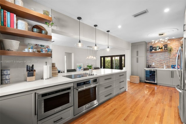 kitchen with stainless steel appliances, wine cooler, gray cabinets, open shelves, and visible vents