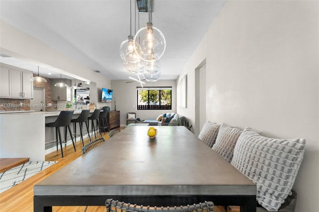 dining space with wood finished floors and a notable chandelier