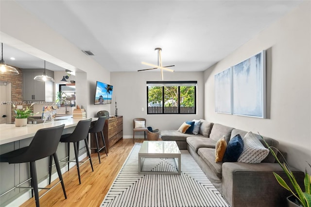 living room with visible vents, baseboards, and light wood-type flooring