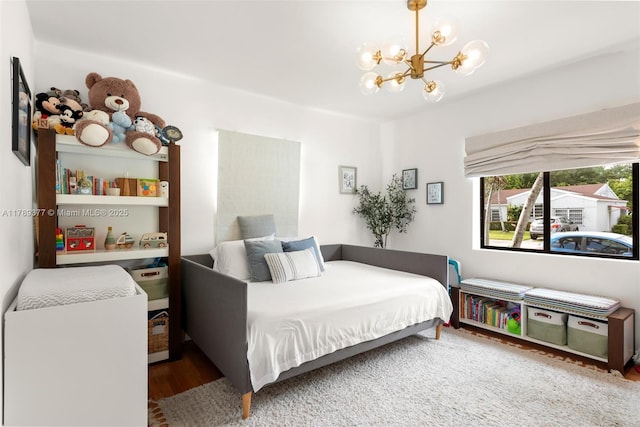 bedroom with a notable chandelier and wood finished floors