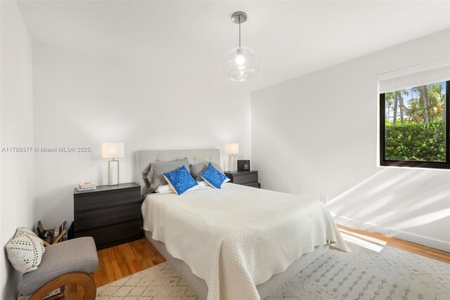 bedroom with wood finished floors and baseboards