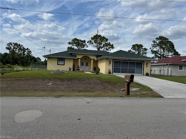 1127 Foggia St E, Lehigh Acres, FL 33974 - view of front of home featuring an attached garage, a front lawn, driveway, and stucco siding