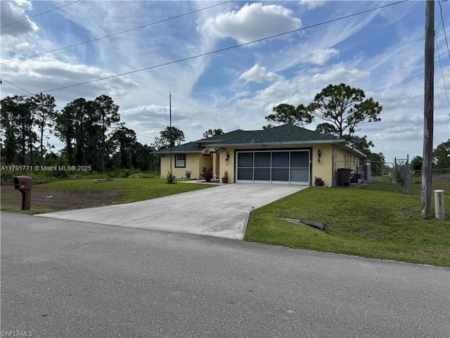 1127 Foggia St E, Lehigh Acres, FL 33974 - ranch-style house featuring stucco siding, fence, driveway, a front yard, and an attached garage