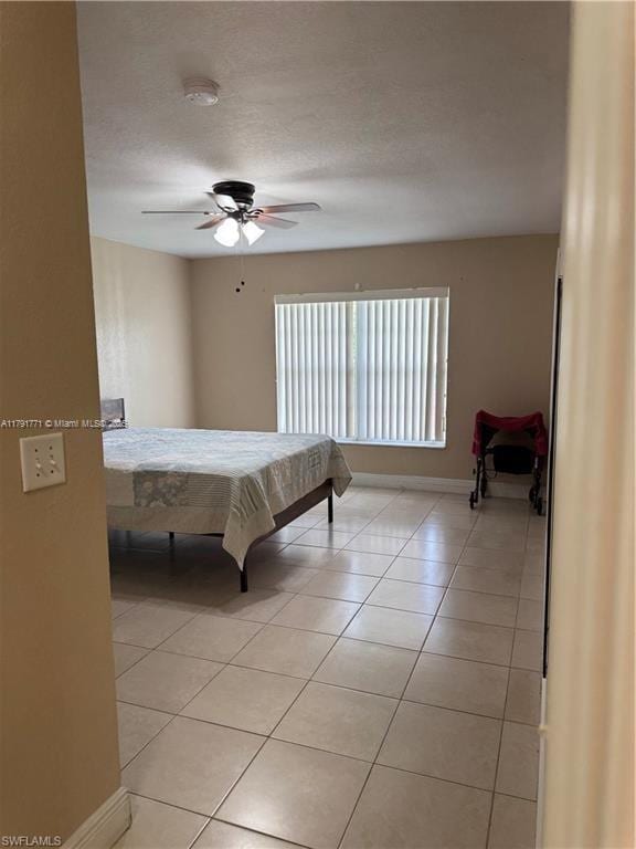 1127 Foggia St E, Lehigh Acres, FL 33974 - bedroom featuring baseboards, light tile patterned floors, and a ceiling fan