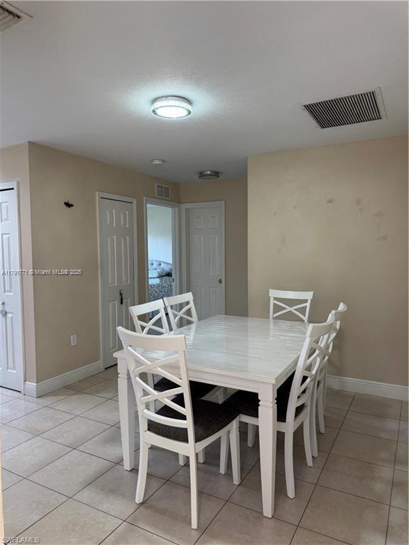 1127 Foggia St E, Lehigh Acres, FL 33974 - dining space featuring light tile patterned floors, visible vents, and baseboards