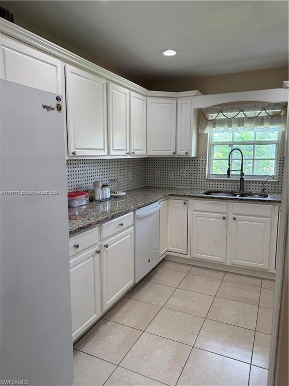 1127 Foggia St E, Lehigh Acres, FL 33974 - kitchen with white cabinets, white appliances, light tile patterned flooring, and a sink