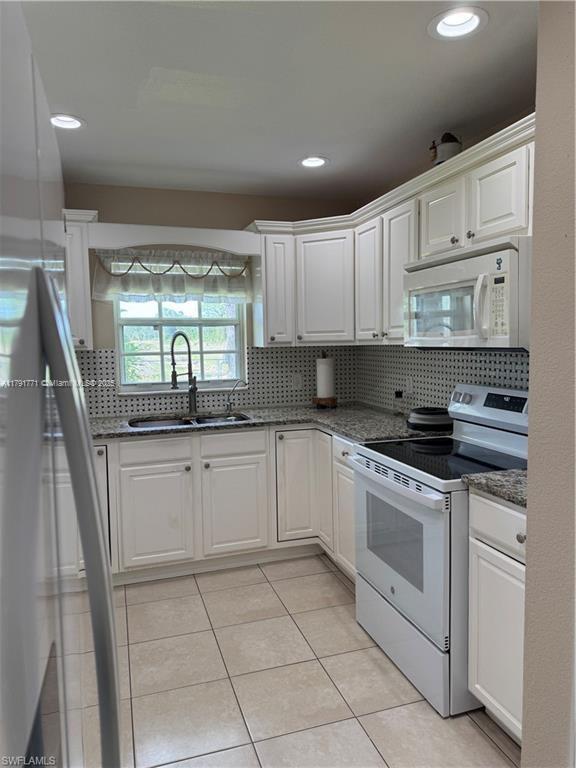 1127 Foggia St E, Lehigh Acres, FL 33974 - kitchen featuring white cabinetry, white appliances, and a sink
