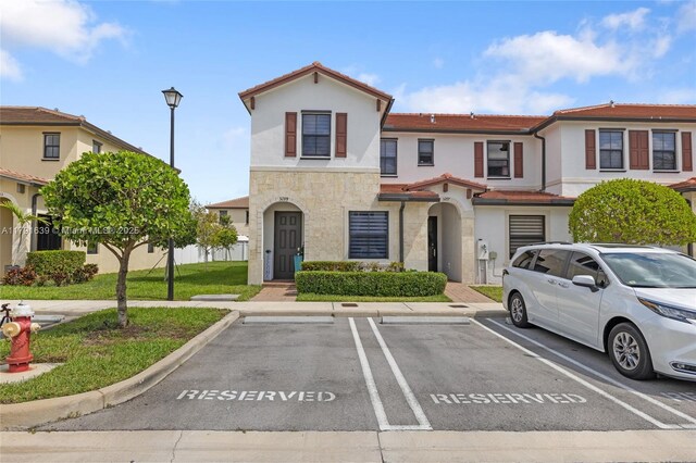 3289 W 106th Ter, Hialeah, FL 33018 - view of front facade with a tile roof, uncovered parking, stone siding, and stucco siding