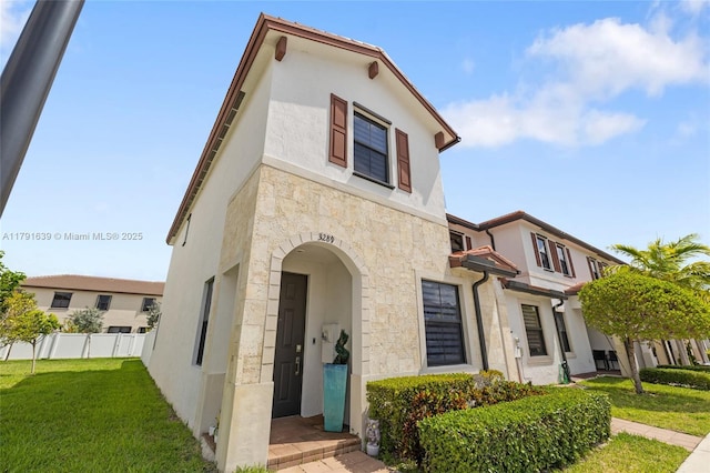 3289 W 106th Ter, Hialeah, FL 33018 - mediterranean / spanish house with stucco siding, fence, a front lawn, and stone siding