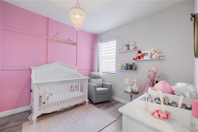 3289 W 106th Ter, Hialeah, FL 33018 - bedroom with wood finished floors, a chandelier, a nursery area, and baseboards