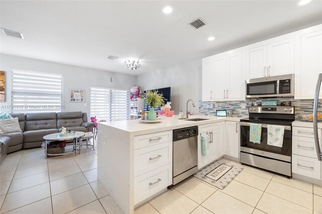 3289 W 106th Ter, Hialeah, FL 33018 - kitchen featuring decorative backsplash, a sink, appliances with stainless steel finishes, visible vents, and open floor plan