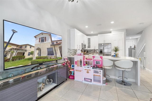 3289 W 106th Ter, Hialeah, FL 33018 - kitchen featuring decorative backsplash, stainless steel appliances, light countertops, a peninsula, and light tile patterned flooring