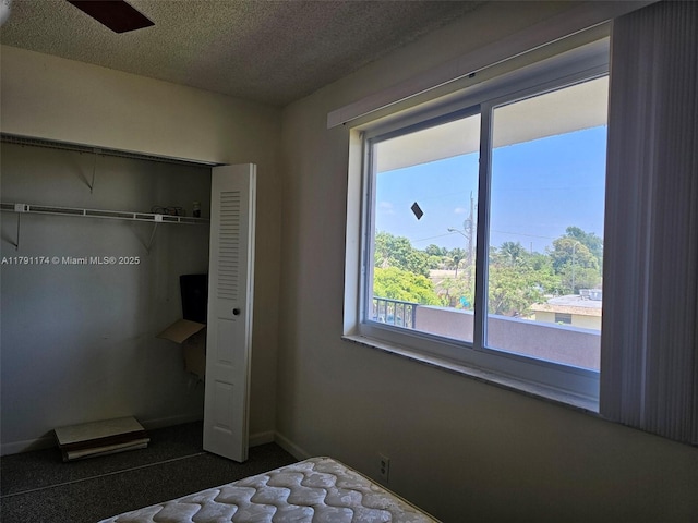 1103 NW 58th Ter Unit 321, Sunrise, FL 33313 - bedroom with a textured ceiling, a closet, and dark carpet