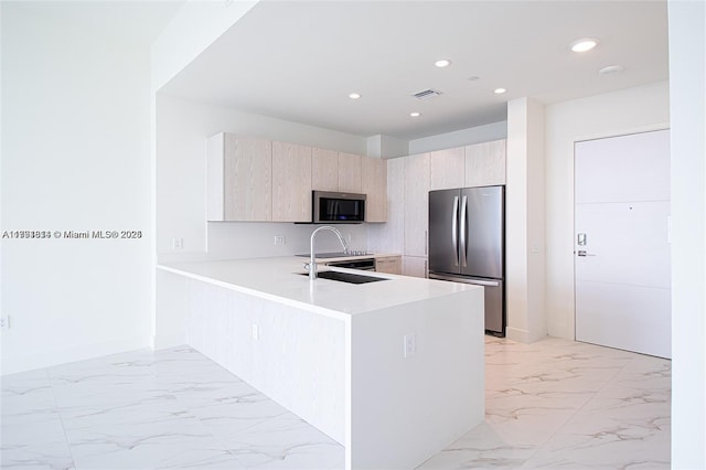 2000 Metropica Way Unit 2605, Sunrise, FL 33323 - kitchen featuring stainless steel appliances, light marble finish flooring, light countertops, light brown cabinets, and a peninsula