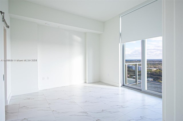 2000 Metropica Way Unit 2605, Sunrise, FL 33323 - spare room with marble look tiles, a barn door, and baseboards