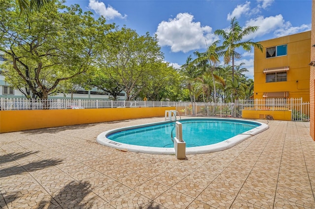 pool with fence and a patio