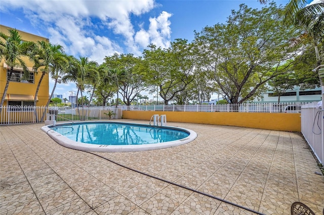 community pool featuring a patio and fence