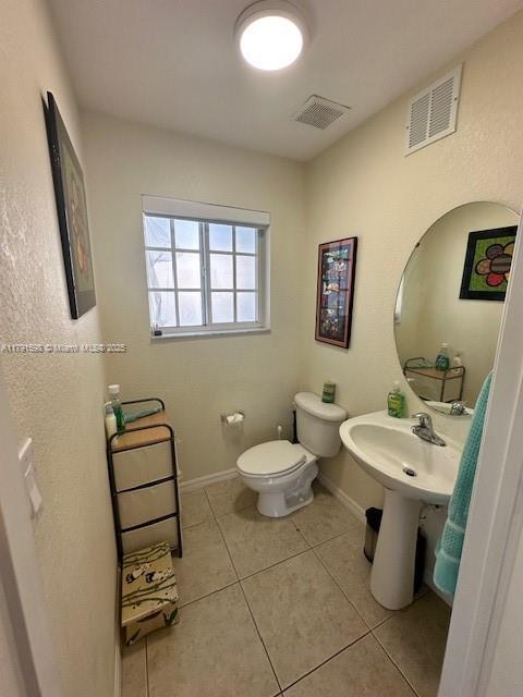 212 NE 3rd St Unit 12, Hallandale Beach, FL 33009 - bathroom featuring toilet, tile patterned floors, visible vents, and baseboards