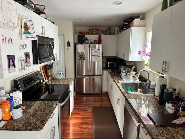 212 NE 3rd St Unit 12, Hallandale Beach, FL 33009 - kitchen with white cabinets, dark countertops, appliances with stainless steel finishes, a sink, and dark wood-type flooring