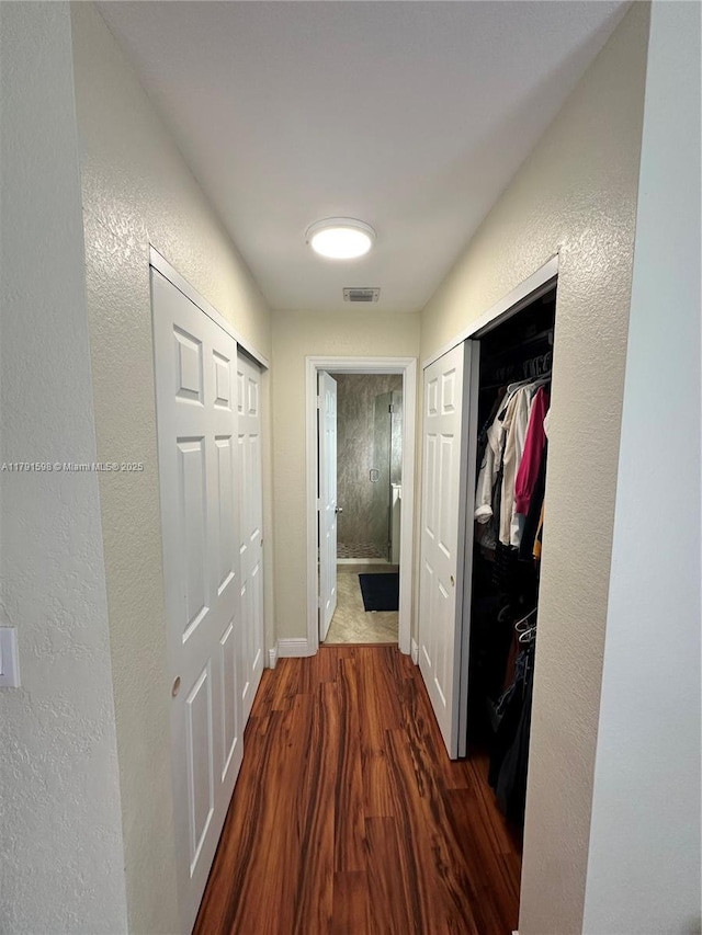 212 NE 3rd St Unit 12, Hallandale Beach, FL 33009 - hall featuring a textured wall, visible vents, dark wood-style floors, and baseboards