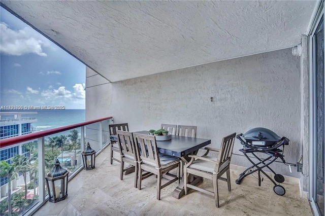balcony with a water view and outdoor dining area