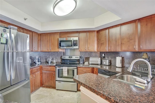 kitchen featuring brown cabinetry, stainless steel appliances, and decorative backsplash