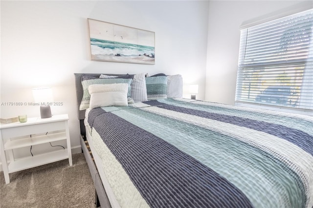 bedroom with baseboards and carpet