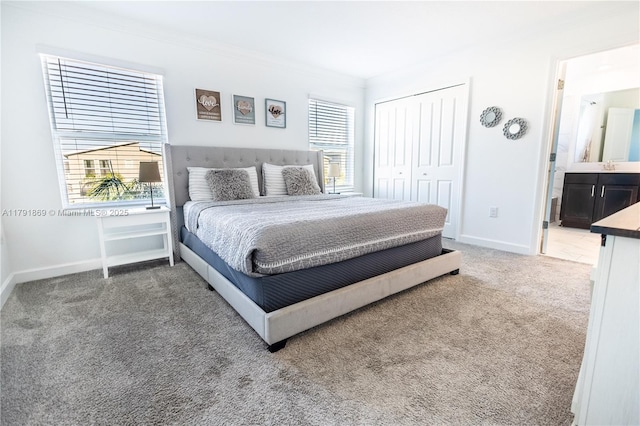 bedroom with baseboards, a closet, carpet, and a sink