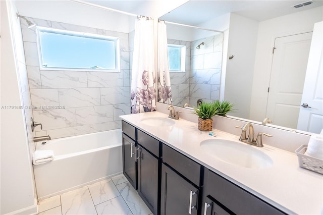 full bathroom featuring visible vents, marble finish floor, shower / tub combo with curtain, and a sink
