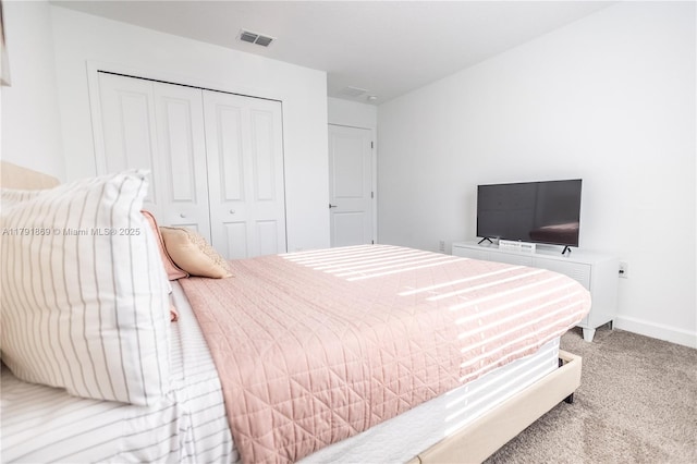 carpeted bedroom featuring baseboards, visible vents, and a closet