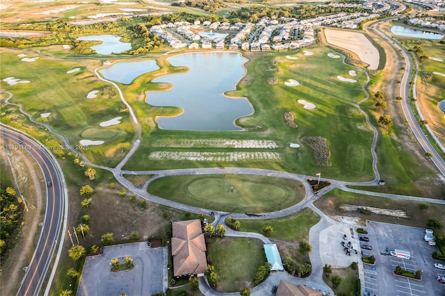 aerial view with golf course view and a water view