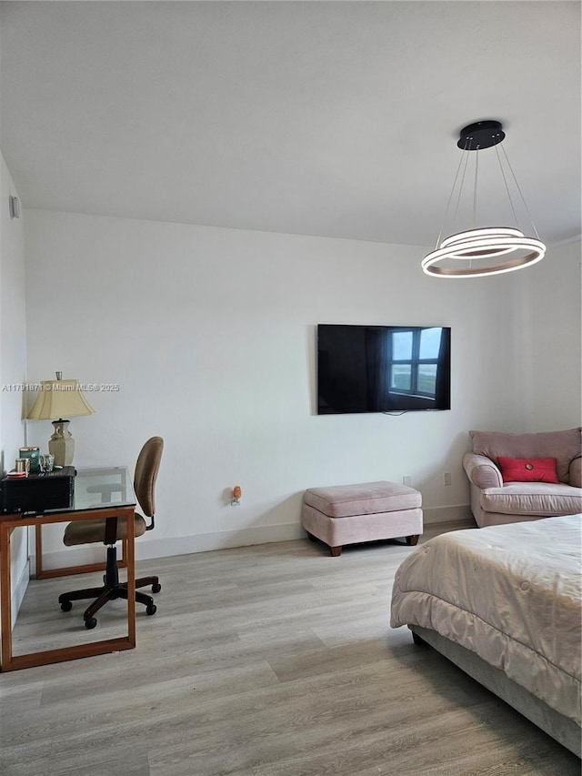 bedroom featuring baseboards and wood finished floors